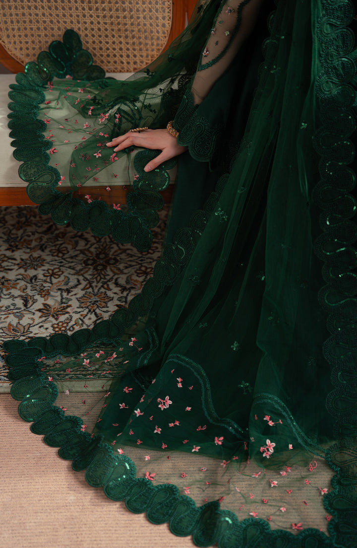 Green embroidered fabric draped over a chair with a person partially visible | Elvin Collection By fabiha fatima